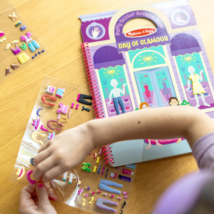 A kid playing with The Melissa & Doug Puffy Sticker Activity Book: Day of Glamour - 196 Reusable Stickers