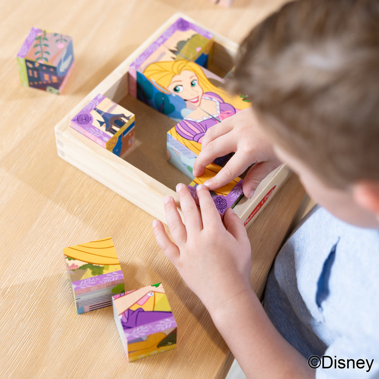 A kid playing with The Melissa & Doug Disney Princess Wooden Toy Cube Puzzle Blocks for Boys and for Girls 3+