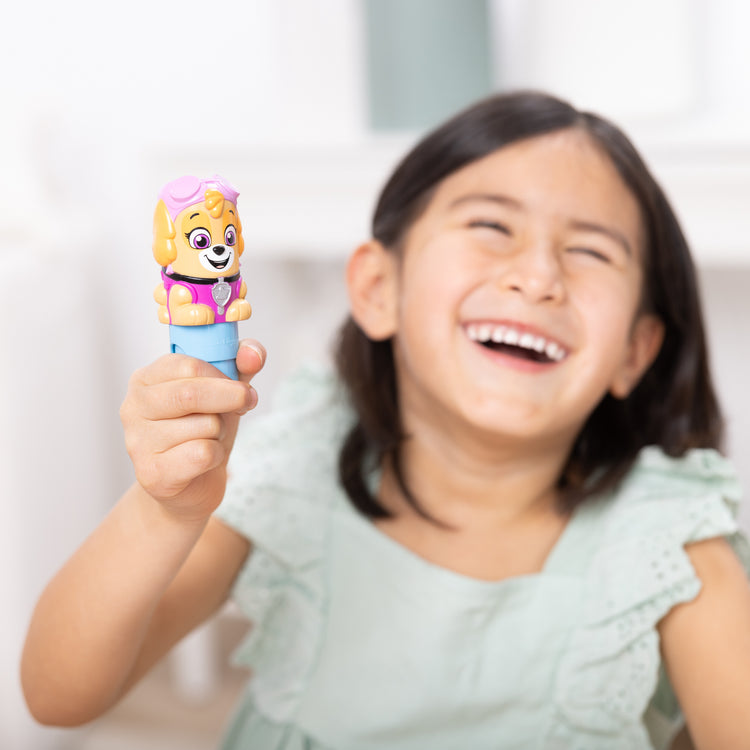 A kid playing with The Melissa & Doug Sticker WOW!™ 24-Page Activity Pad and Sticker Stamper, 300 Stickers, Arts and Crafts Fidget Toy Collectible Character – PAW Patrol Skye
