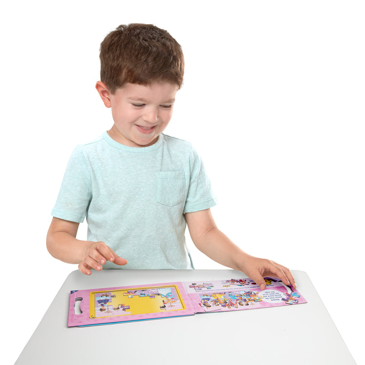 A child on white background with The Melissa & Doug Take-Along Magnetic Jigsaw Puzzles Travel Toy – Princesses (2 15-Piece Puzzles)