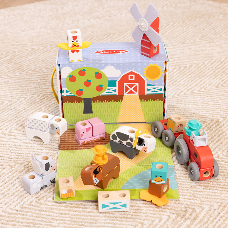 A playroom scene with The Melissa & Doug Blockables™ Farm and Farm Friends 2-Pack Bundle Connectable Wooden Building Blocks Preschool Play Set Toy