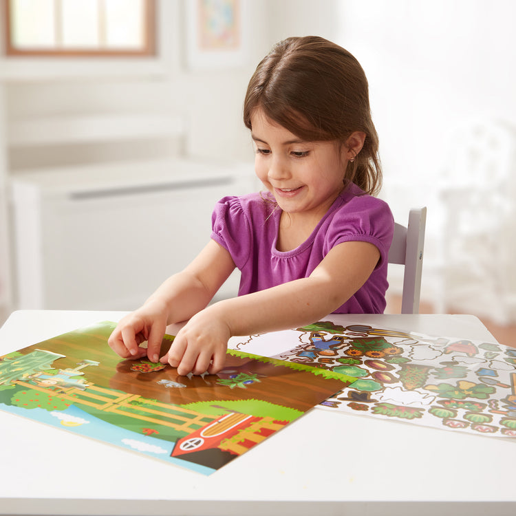 A kid playing with The Melissa & Doug Reusable Sticker Pad: Farm - 280+ Stickers, 5 Scenes
