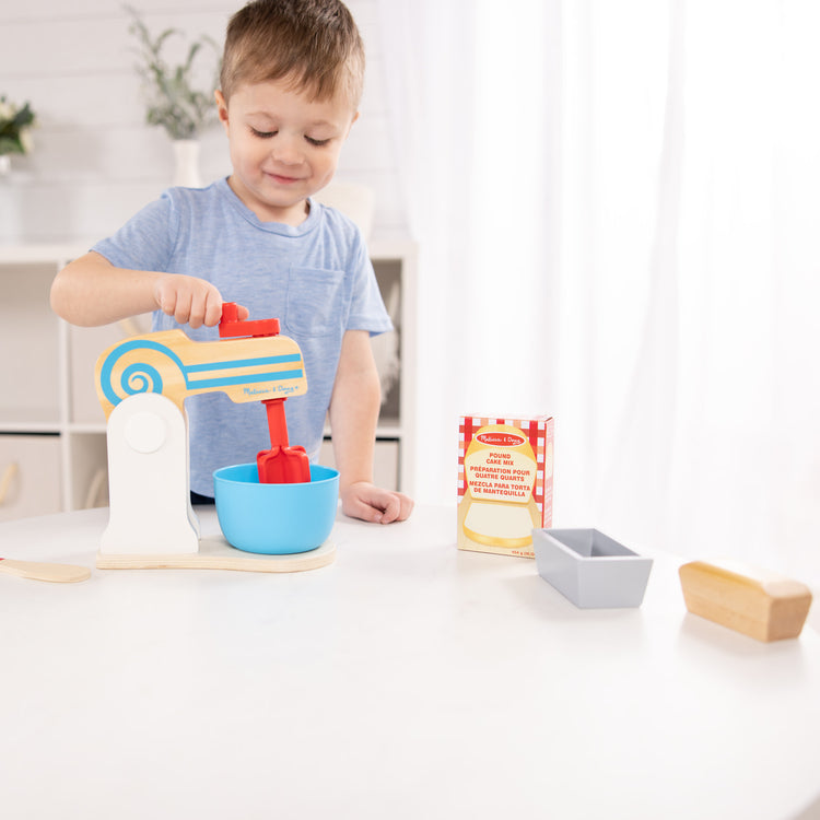 A kid playing with The Melissa & Doug Wooden Make-a-Cake Mixer Set (11 pcs) - Play Food and Kitchen Accessories