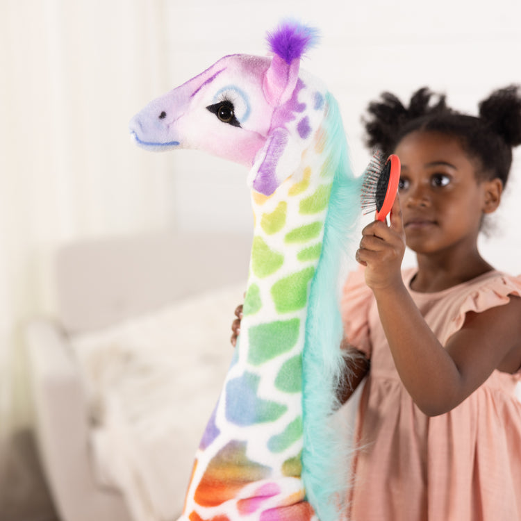 A kid playing with The MelissaAndDoug.com Exclusive: Rainbow Giraffe Lifelike Plush