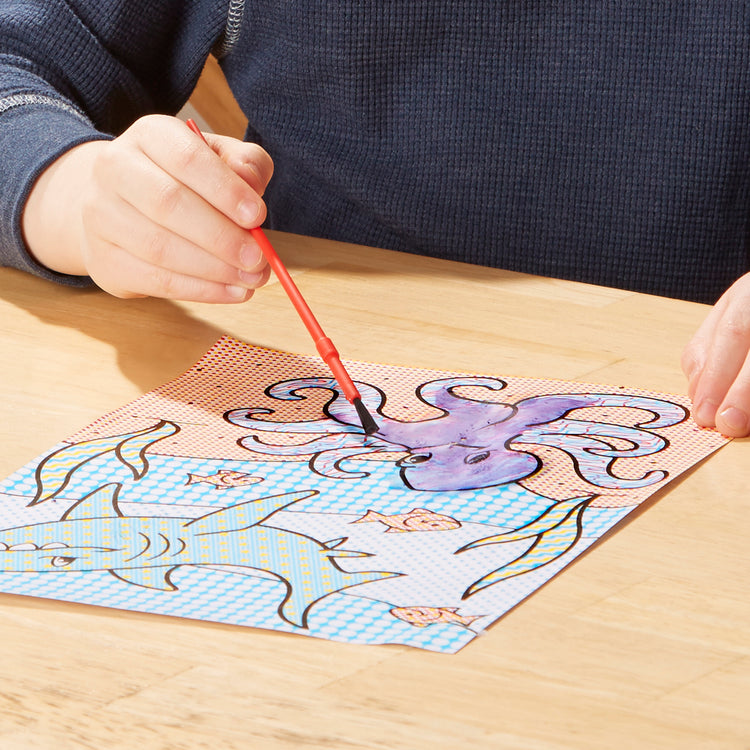 A kid playing with The Melissa & Doug My First Paint With Water Coloring Book: Animals (24 Painting Pages)