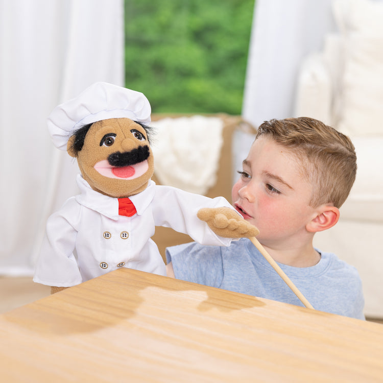 A kid playing with The Melissa & Doug Chef Puppet (Al Dente) with Detachable Wooden Rod
