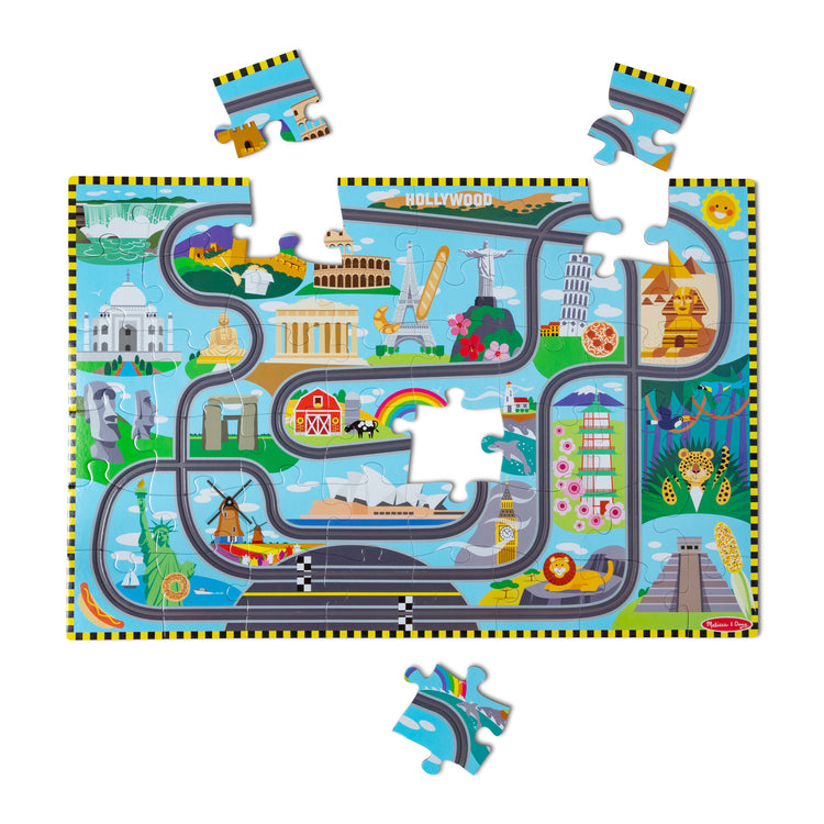The loose pieces of The Melissa & Doug Race Around the World Tracks Cardboard Jigsaw Floor Puzzle and Wind-Up Vehicles – 48 Pieces, for Boys and Girls 3+