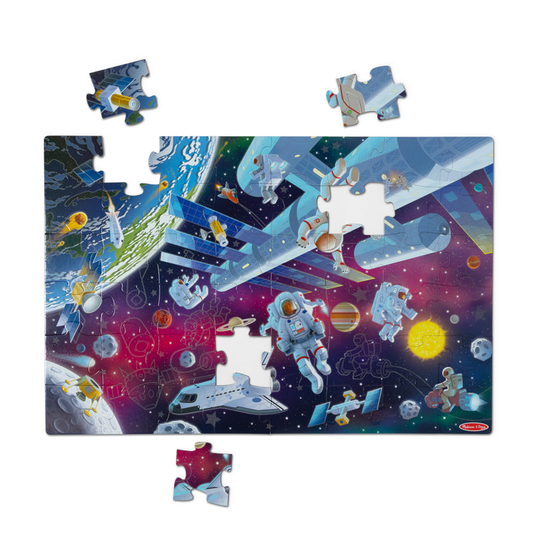 The loose pieces of The Melissa & Doug Outer Space Glow-in-the-Dark Cardboard Jigsaw Floor Puzzle – 48 Pieces, for Boys and Girls 3+