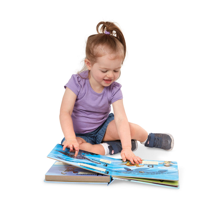A child on white background with The Melissa & Doug Children's Book - Poke-A-Dot: Dinosaurs A to Z (Board Book with Buttons to Pop)