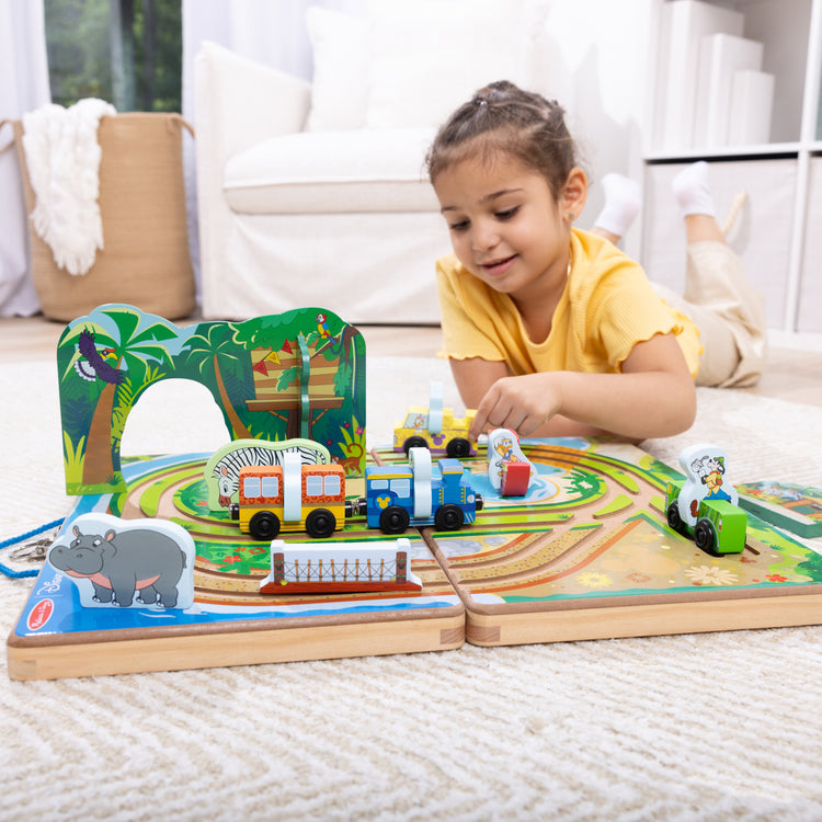 A kid playing with The Melissa & Doug Disney Take-Along Safari Adventure Wooden Play Set with Built-In Tracks – 20 Pieces | Mickey Mouse, Minnie, Wooden Toy for Boys and for Girls 3+