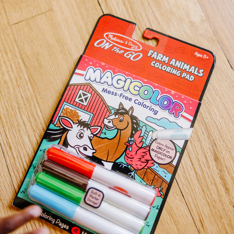 A kid playing with The Melissa & Doug On the Go Magicolor Coloring Pad with 4 Mess-Free Markers, Travel Toy for Boys and Girls Ages 3+  - Farm Animals 