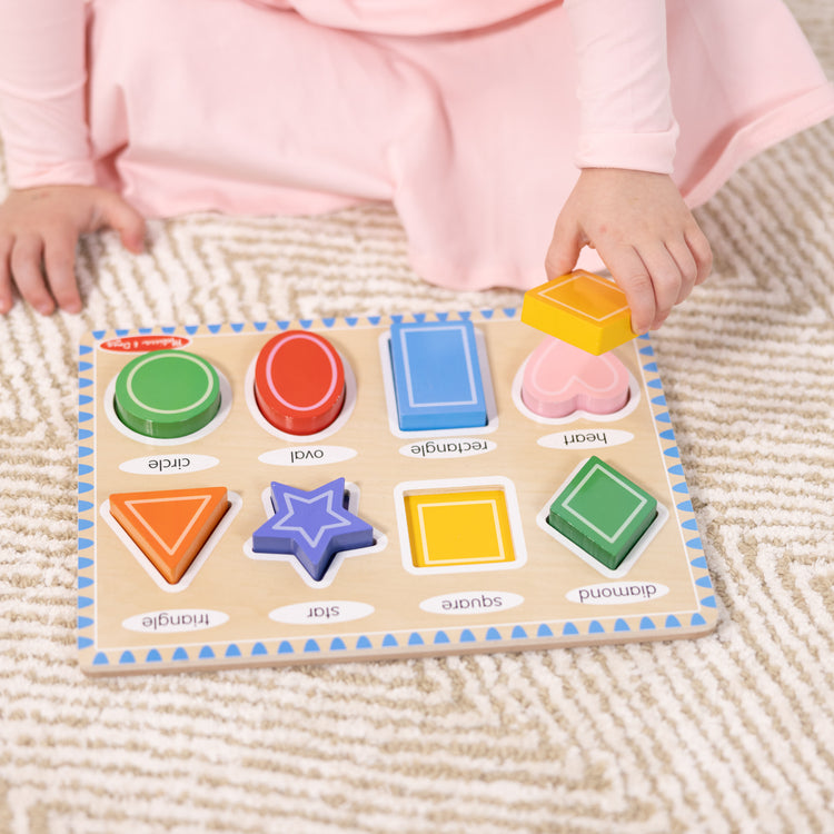A kid playing with The Melissa & Doug Shapes Wooden Chunky Puzzle (8 pcs)