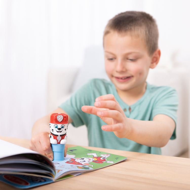 A kid playing with The Melissa & Doug Sticker WOW!™ 24-Page Activity Pad and Sticker Stamper, 300 Stickers, Arts and Crafts Fidget Toy Collectible Character – PAW Patrol Marshall