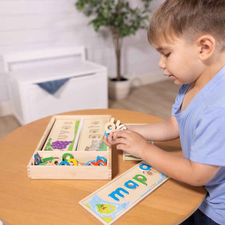 A kid playing with The Melissa & Doug Spanish See & Spell Educational Language Learning Toy