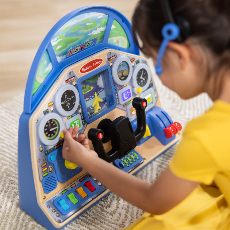 A kid playing with The Melissa & Doug Jet Pilot Interactive Dashboard Wooden Toy for Boys and Girls Ages 3+