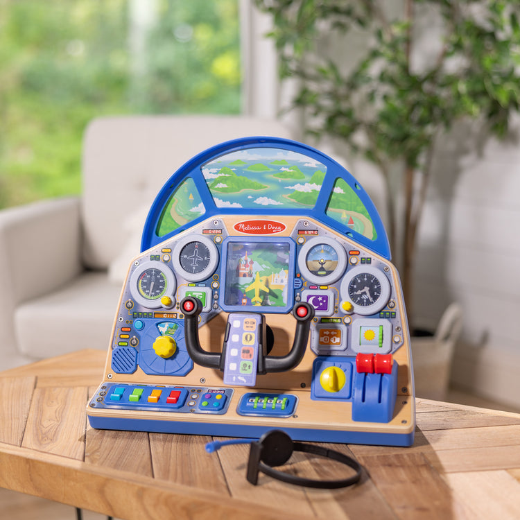 A playroom scene with The Melissa & Doug Jet Pilot Interactive Dashboard Wooden Toy for Boys and Girls Ages 3+