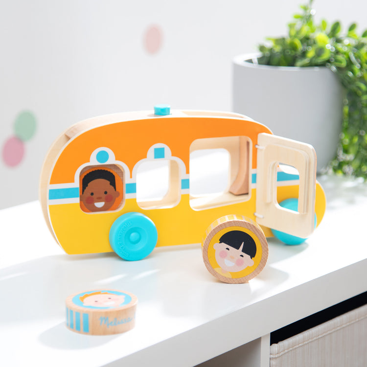 A playroom scene with The Melissa & Doug GO Tots Wooden Roll & Ride Bus with 3 Disks