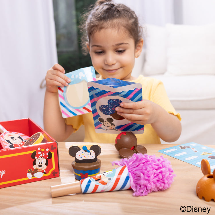 A kid playing with The Melissa & Doug Disney Snacks & Popcorn Wooden Play Food Set – 24 Pieces | Mickey Mouse, Minnie, Wooden Toy for Boys and for Girls 3+