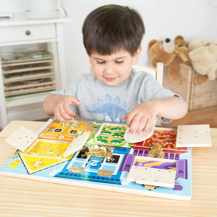 A kid playing with The Melissa & Doug Latches Wooden Activity Board