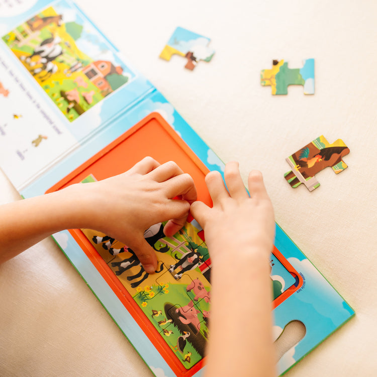 A kid playing with The Melissa & Doug Take-Along Magnetic Jigsaw Puzzles Travel Toy On the Farm (2 15-Piece Puzzles)