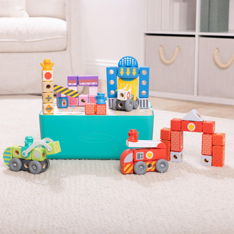 A playroom scene with The Melissa & Doug Blockables™ Deluxe City Snap And Play Amazon Exclusive, Mix and Match Connectable Wooden Building Blocks Play Set With Storage Bin and Play Lid (122 Pcs)