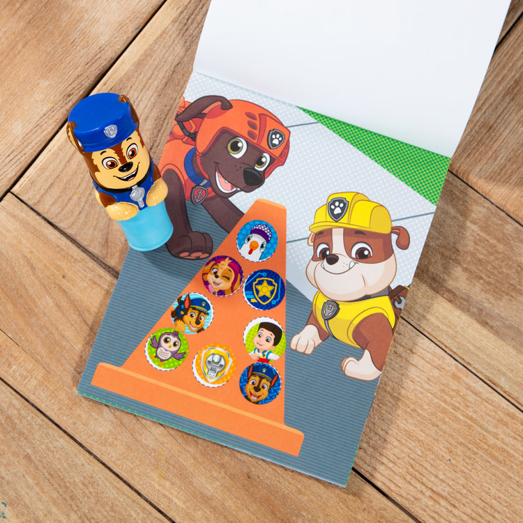 A playroom scene with The Melissa & Doug Sticker WOW!™ 24-Page Activity Pad and Sticker Stamper, 300 Stickers, Arts and Crafts Fidget Toy Collectible Character – PAW Patrol Chase
