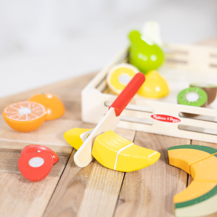 A playroom scene with The Melissa & Doug Cutting Fruit Set - Wooden Play Food Kitchen Accessory, Multi