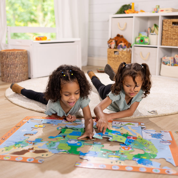 A kid playing with The Melissa & Doug National Parks U.S.A. Map Floor Puzzle – 45 Jumbo and Animal Shaped Pieces, Search-and-Find Activities, Park and Animal ID Guide