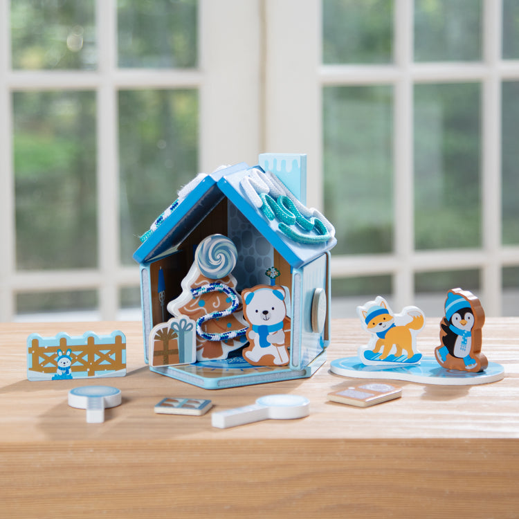 A playroom scene with The Melissa & Doug Winter Frost Wooden Gingerbread House Play Set for Boys and Girls 3+ 