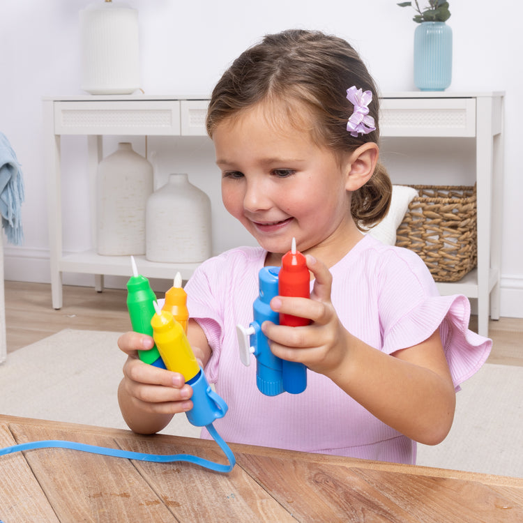 A kid playing with The Melissa & Doug Water WOW! Pen Pack - 4 Color-with-Water Pens, Sprayer, Tether Cap