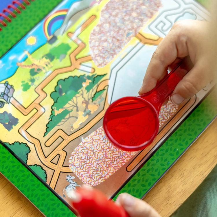 A kid playing with The Melissa & Doug On the Go Water Wow! Reusable Water-Reveal Deluxe Activity Pad – Adventure