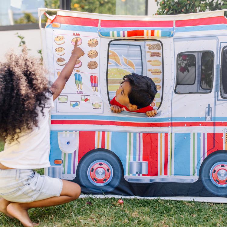 A kid playing with The Melissa & Doug Food Truck Play Tent