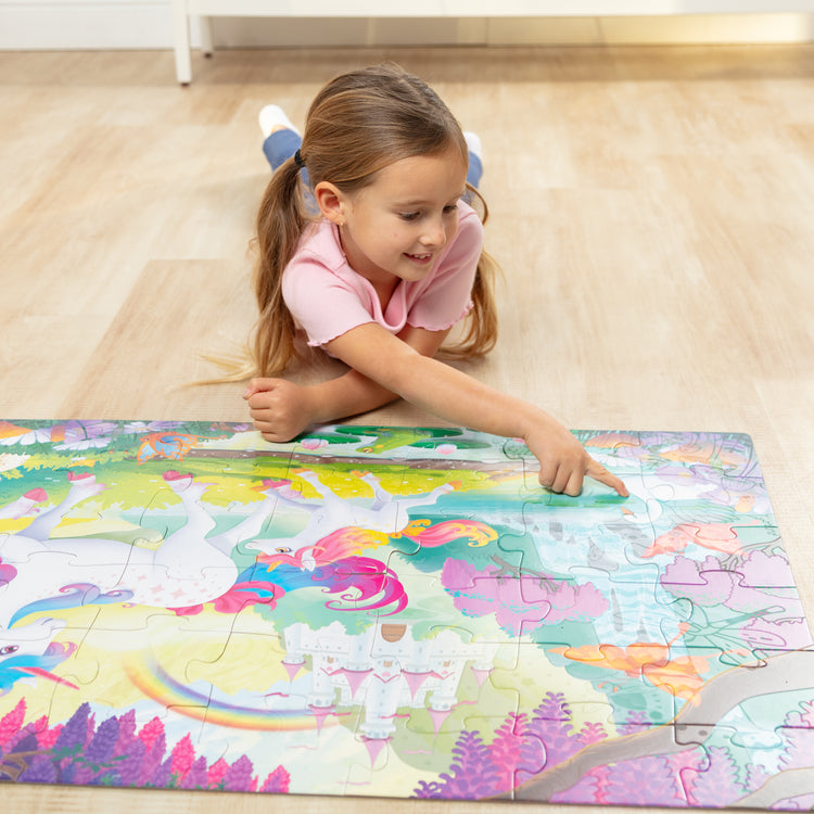 A kid playing with The GID Unicorn Floor Puzzle