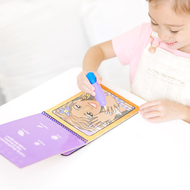 A kid playing with The Melissa & Doug On the Go Water Wow! Reusable Water-Reveal Activity Pad - Makeup and Manicures