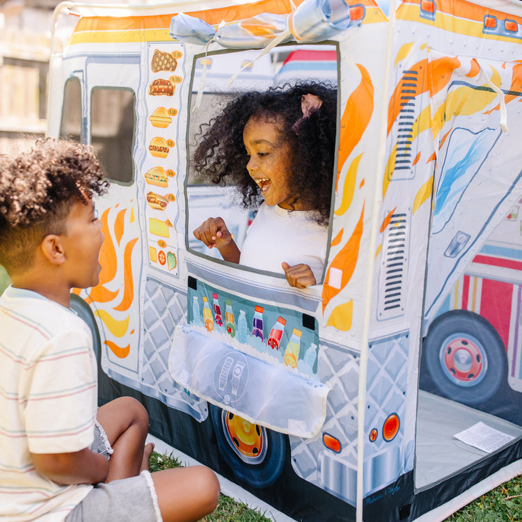 A kid playing with The Melissa & Doug Food Truck Play Tent