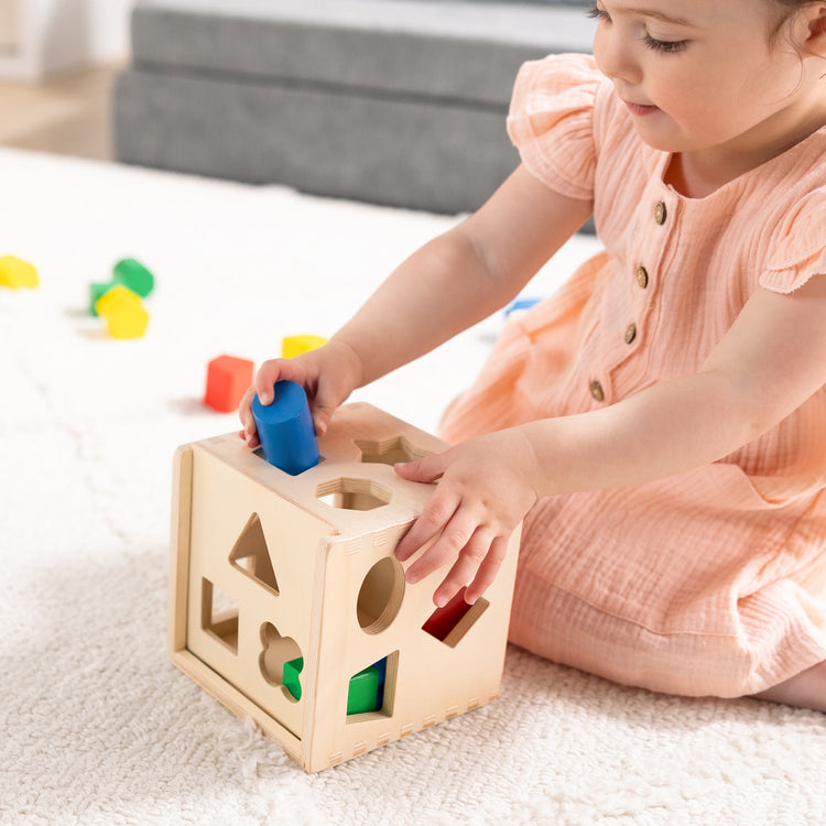 A kid playing with The Melissa & Doug 4 Wooden Classic Rainbow Learning Toys