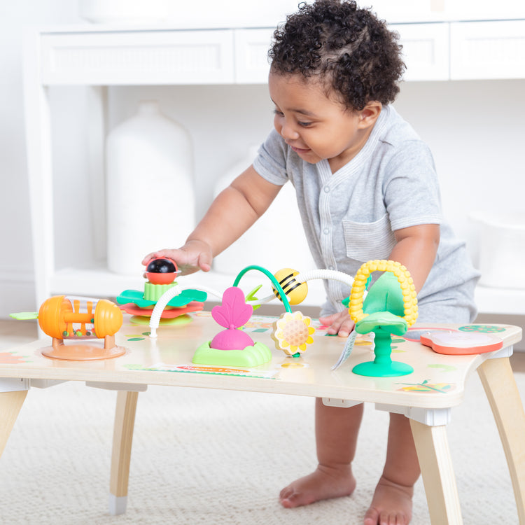 A kid playing with The Farmers Market 3 in 1 Activity Center