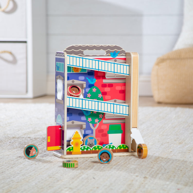 A playroom scene with The Melissa & Doug GO Tots Wooden Town House Tumble with 6 Disks