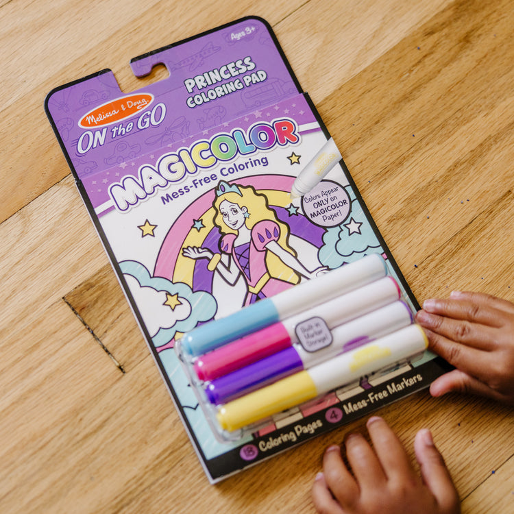 A kid playing with The Melissa & Doug On the Go Magicolor Coloring Pad - Princess (18 Pages)