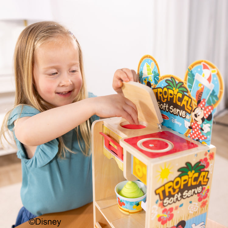A kid playing with The Disney Tropical Soft Serve Ice Cream Wooden Play Food Set – 23 Pieces | Mickey Mouse, Minnie, Wooden Toy for Boys and for Girls 3+