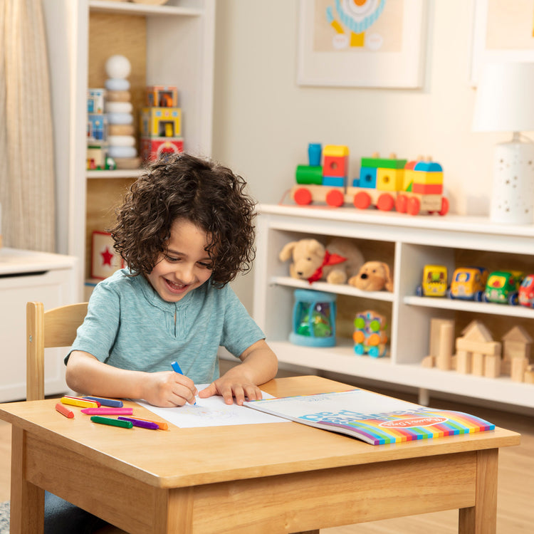 A kid playing with The Melissa & Doug Drawing Pad (9 x 12 inches) With 50 Sheets of White Bond Paper