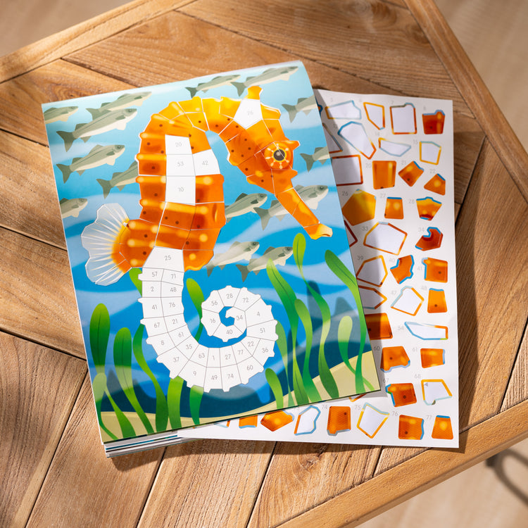 A playroom scene with The Melissa & Doug Mosaic Sticker Pad Ocean Animals (12 Color Scenes to Complete with 850+ Stickers)