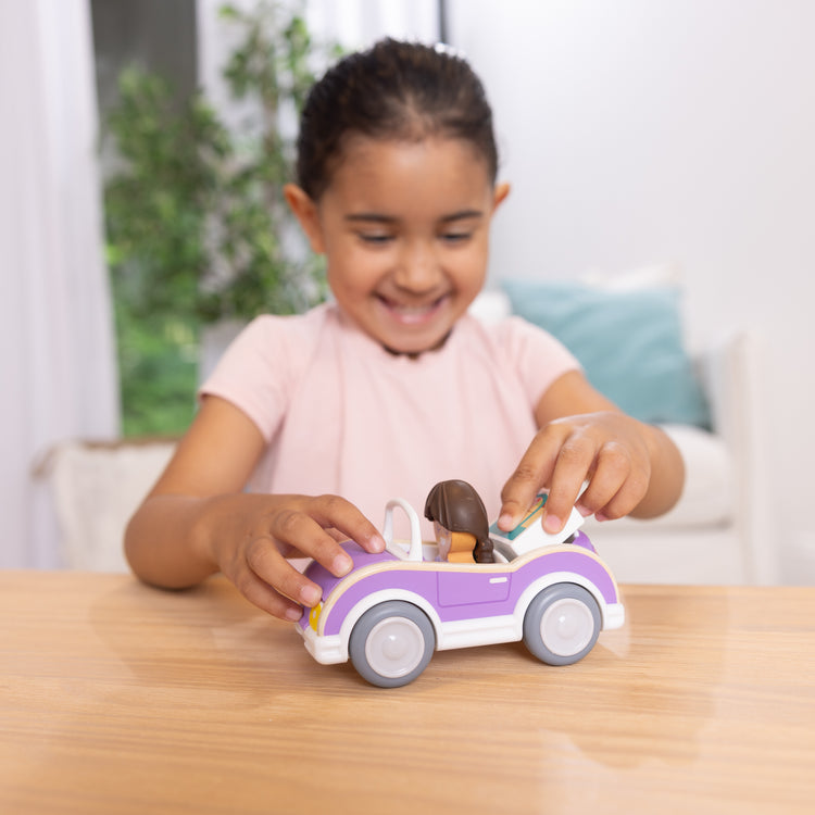 A kid playing with The Melissa & Doug Cheery Lane Vehicle and Girl Figure, Wooden Toy Convertible Car Playset - For Ages 2+