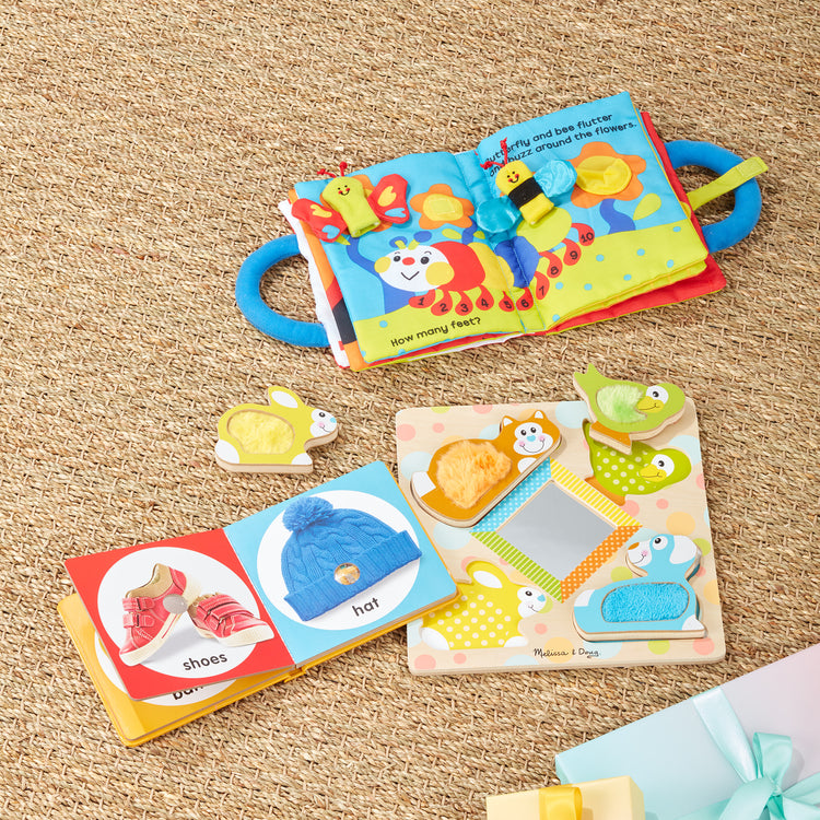 A playroom scene with The Melissa & Doug K’s Kids My First Activity Book 8-Page Soft Book for Babies and Toddlers