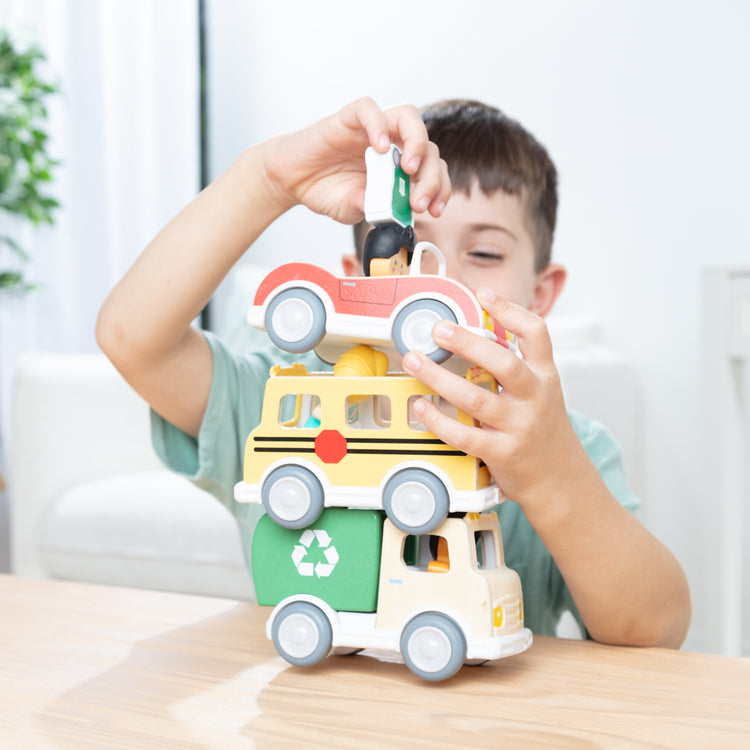 A kid playing with The CheeryLaneVehiclesandPlayFiguresPlaySet