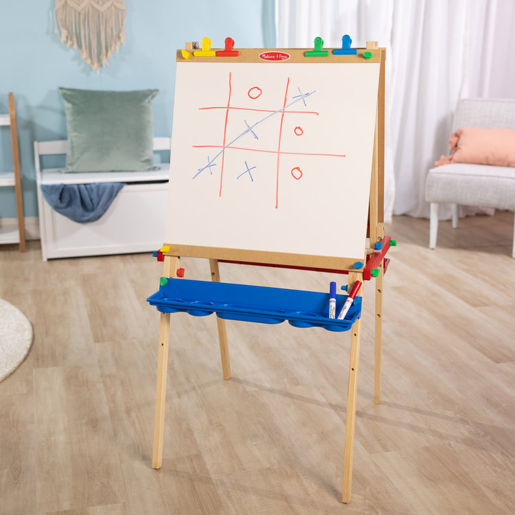 A playroom scene with The Melissa & Doug Deluxe Standing Art Easel - Dry-Erase Board, Chalkboard, Paper Roller