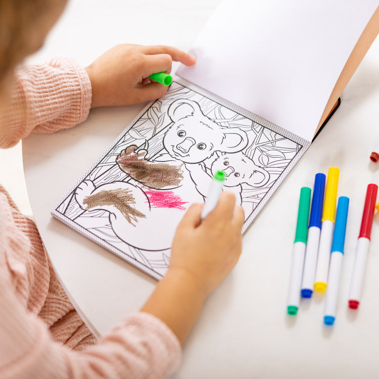 A kid playing with The Magic-Pattern Kids’ Wild Animals Marker Coloring Pad On the Go Travel Activity