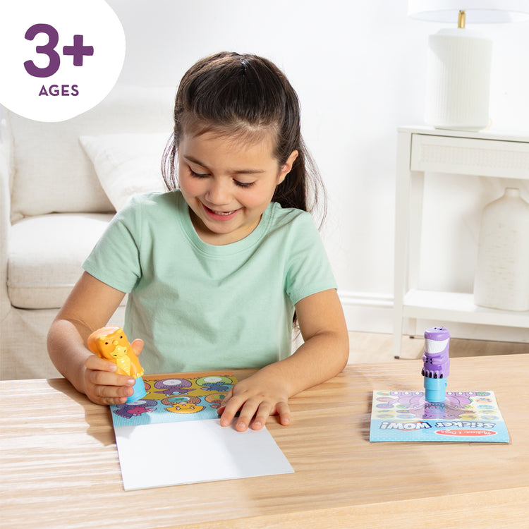 A kid playing with The Melissa & Doug Sticker Wow!™ T-Rex and Triceratops Bundle: Two 24-Page Activity Pads, 2 Sticker Stampers, 900 Stickers, Arts and Crafts Fidget Toy Collectible Characters