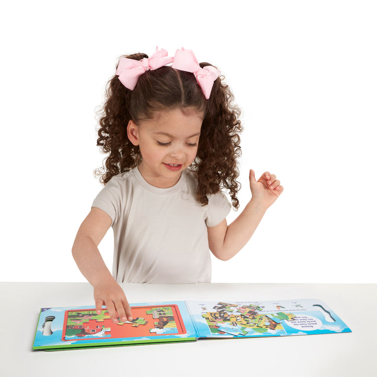 A child on white background with The Melissa & Doug Take-Along Magnetic Jigsaw Puzzles Travel Toy On the Farm (2 15-Piece Puzzles)