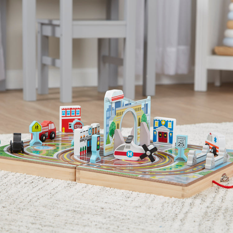 A playroom scene with The Melissa & Doug 18-Piece Wooden Take-Along Tabletop Town, 4 Rescue Vehicles, Play Pieces, Bridge